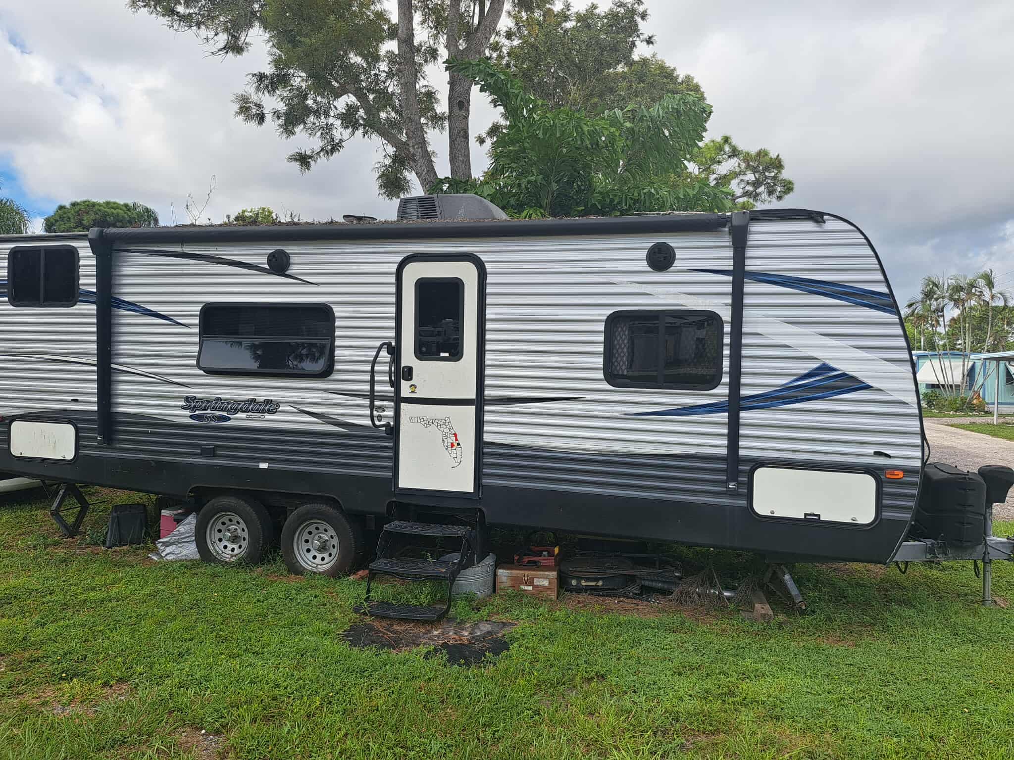 Travel trailer RV on spacious lot with trees